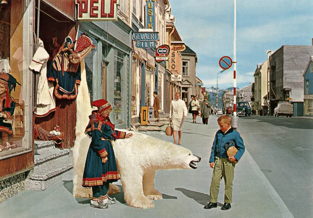 vintage Norwegian postcard with image of a gorl and a boy petting a friendly polar bear on a town street